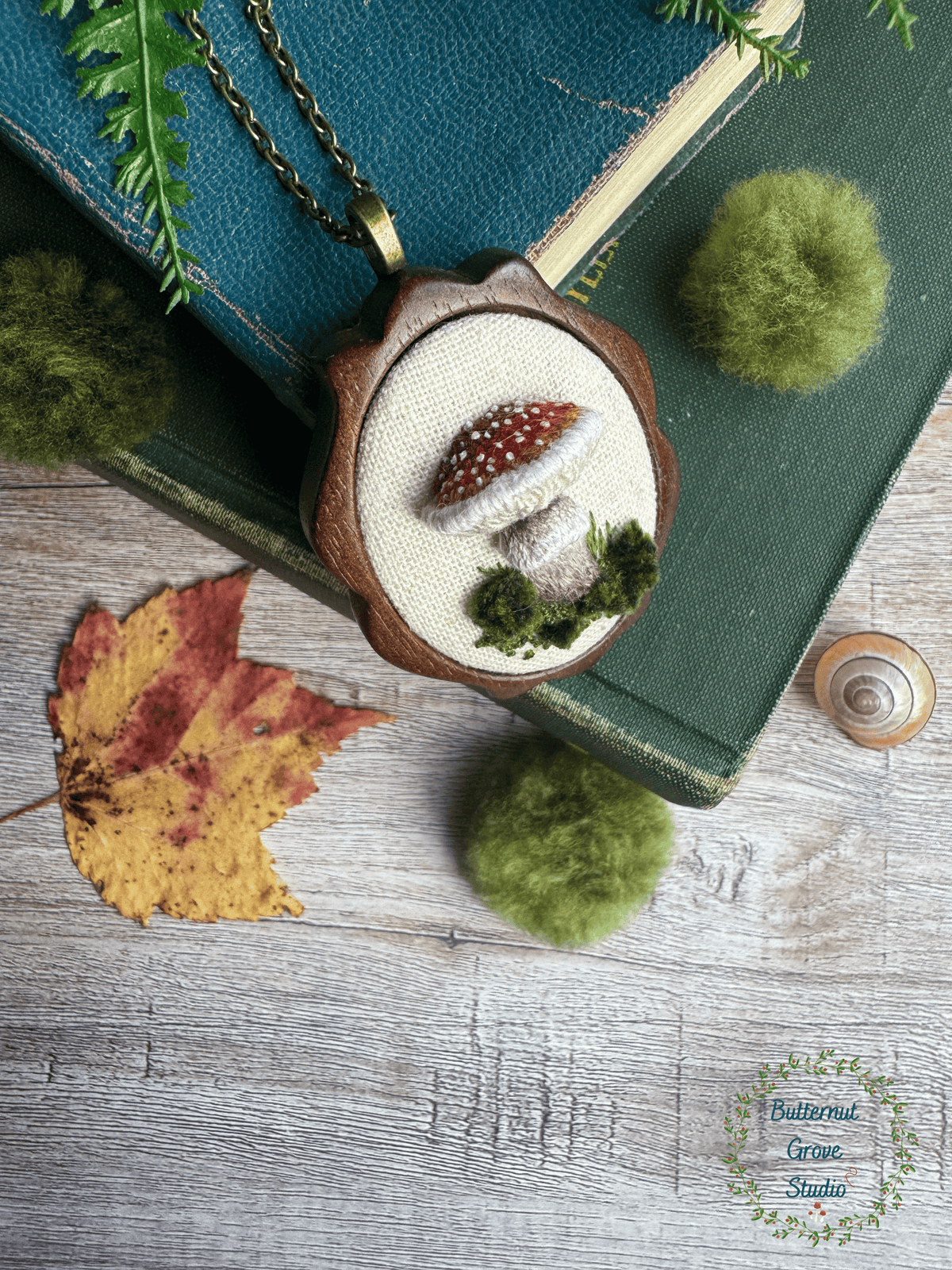 A tiny treasure from the forest floor, stitched by hand. Nestled inside a hand-carved walnut frame, this piece is small enough to wear as a pendant, or to add a bit of magic to your wall as a miniature work of art.  

Dimensions: 1.5" wide × 2" tall
Materials: Hand-stitched embroidery, hand-carved walnut frame

Choose how you would like to enjoy your little woodland treasure:

Please leave a note at checkout with your preference:

• Hand-painted mushroom picture hanger 
• 18" bronze chain with lobster clasp
