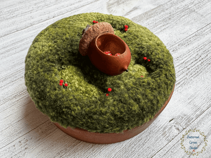 One-of-a-kind 3-inch micro-embroidery featuring a hand-carved acorn surrounded by embroidered moss, British soldier and fairy cup lichens, and tiny woodland details, framed in warm handmade cherry wood frame.